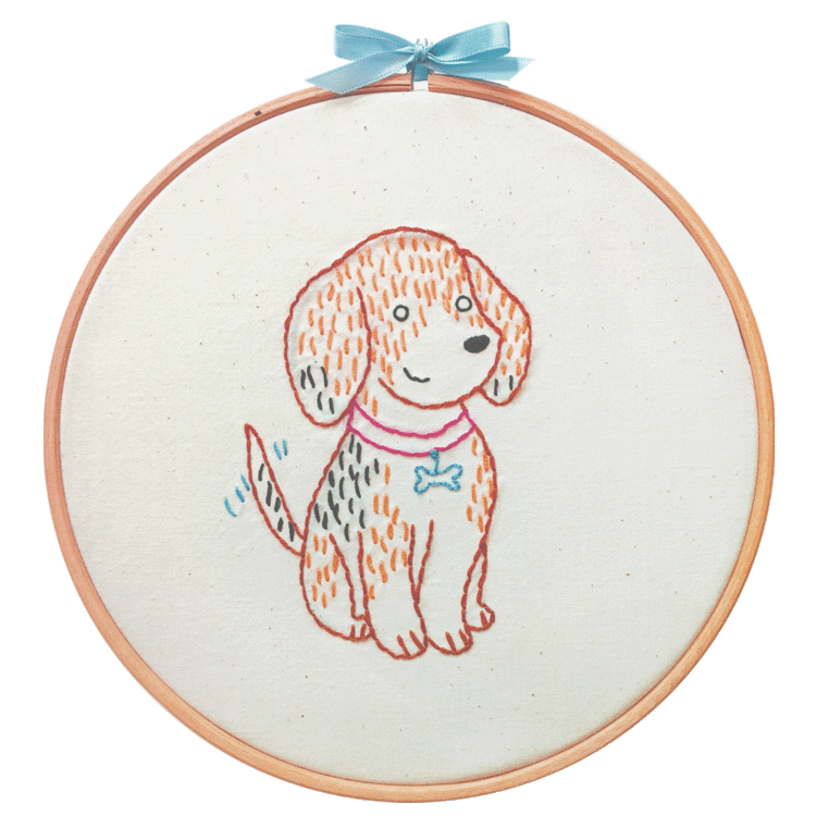 An embroidery hoop with a light blue bow on top with an embroidered puppy on cream colored fabric.