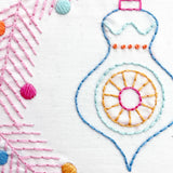 Close-up of colorful embroidery with geometric patterns on a white background