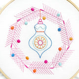Embroidery hoop with a decorative ornament design on a white background