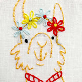 Embroidery of a face with colorful flowers on a white background
