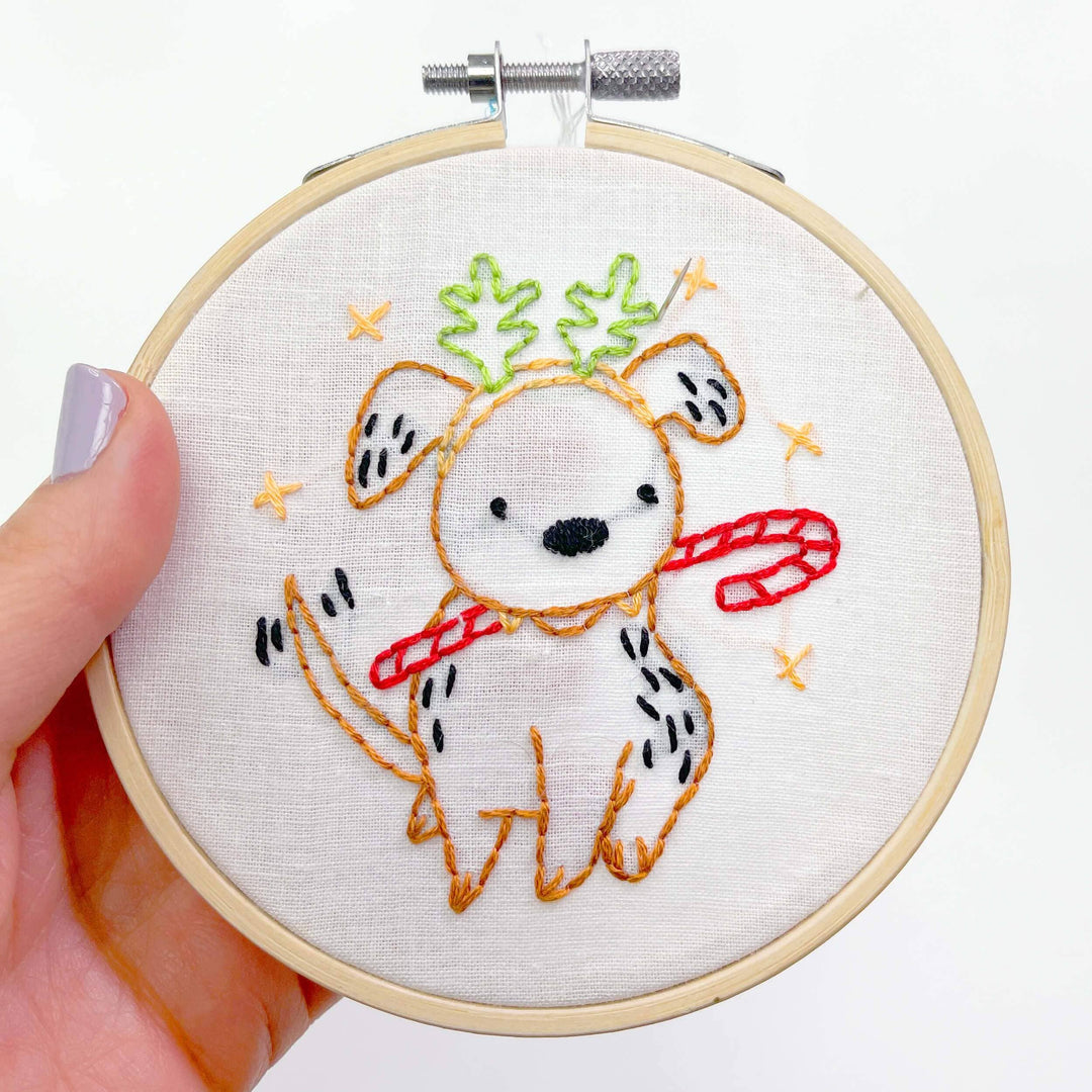 Embroidery hoop with a cute embroidered design of a bear holding an ice cream cone.