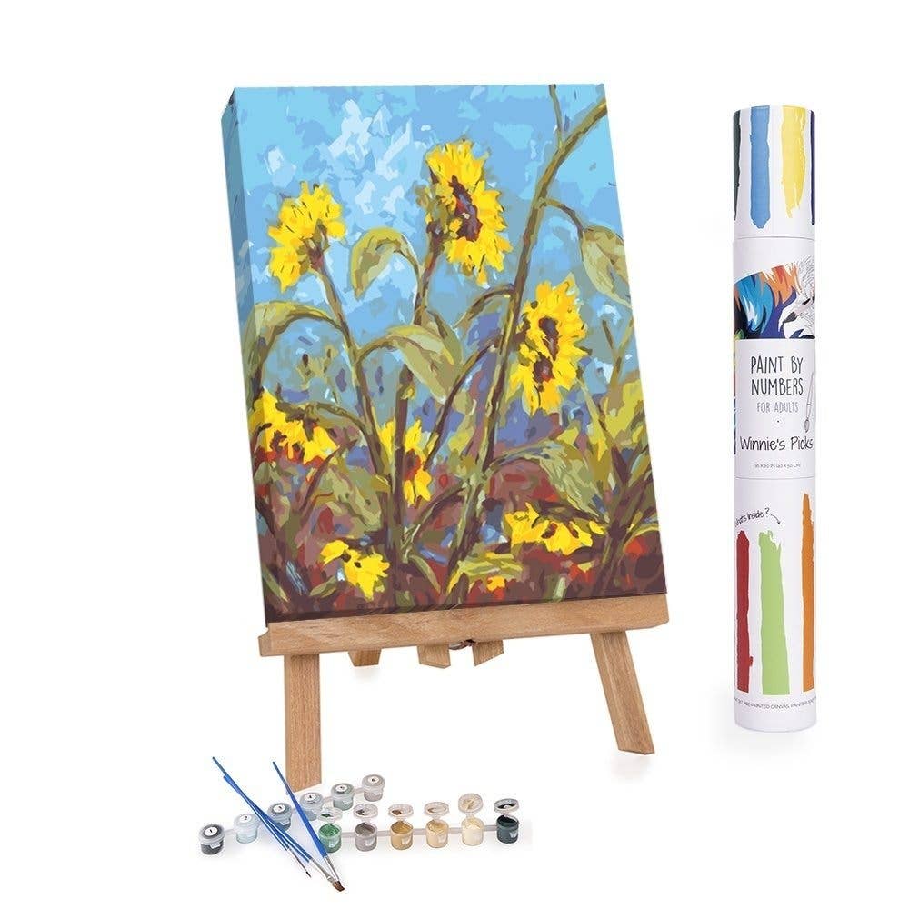 Paint by numbers kit with a completed sunflower painting on an easel.