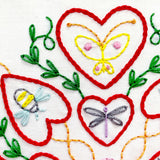Embroidery design with red hearts, a butterfly, a bee, and a dragonfly on a white background.