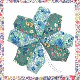 Hexagonal fabric pieces with floral patterns arranged in a circular pattern on a colorful border.