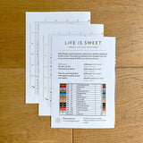 Cross stitch pattern sheet with ruler on a wooden surface