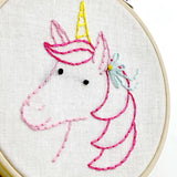 Embroidery hoop with a unicorn design on white fabric