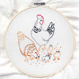Embroidery hoop with a chicken and chicks design on white fabric