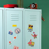 Light blue locker with colorful stickers on a green wall