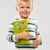 Child holding a green book with cartoon characters on a gray background