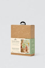 Packaging of a craft kit with wooden design on a white background