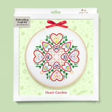 Embroidery craft kit with heart-themed design on a green background