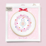 Embroidery craft kit with retro wreath design on a pink background