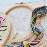 Embroidery hoops with colorful thread and designs on a light surface