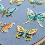 Embroidered butterflies on a blue fabric background