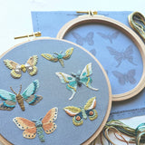 Embroidery hoop with embroidered butterflies on a blue background