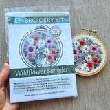 Embroidery kit with wildflower sampler design on a gray surface