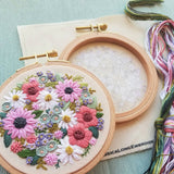 Embroidery hoop with floral design on a light blue background