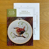 Cross stitch kit with a wren design on a wooden surface