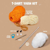 T-shirt yarn kit with orange and white yarn, safety eyes, polyfill, needle, metal crochet hook, and stitch marker on a beige background.