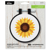Embroidery hoop with a pre-stamped golden sunflower design on a white background, branded with Bucilla.