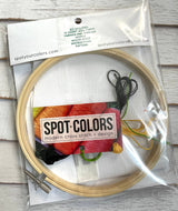 Embroidery hoop with cross stitch kit including thread and hoop, branded 'Spot Your Colors'.