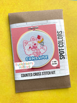 Cross stitch kit packaging with a cartoon character design on a yellow background