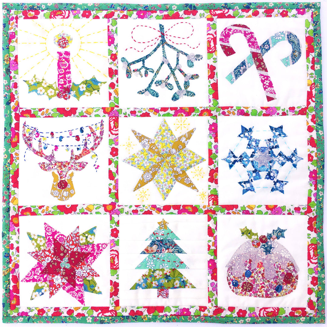 Colorful quilt with various festive designs including stars, trees, and candy canes.