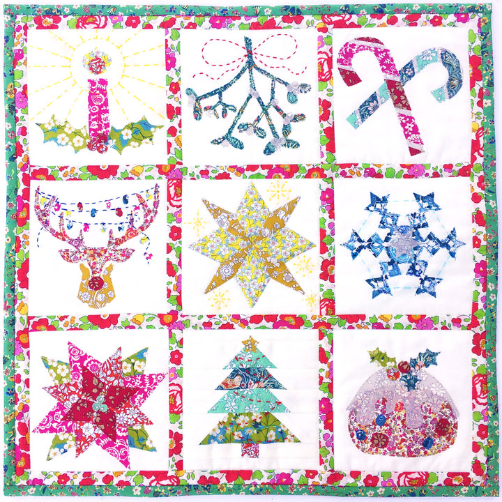 Colorful quilt with various festive designs including stars, trees, and candy canes.