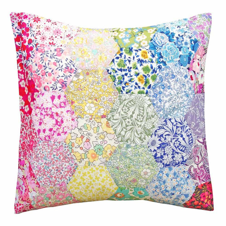 Multicolored floral and patterned pillow on a white background