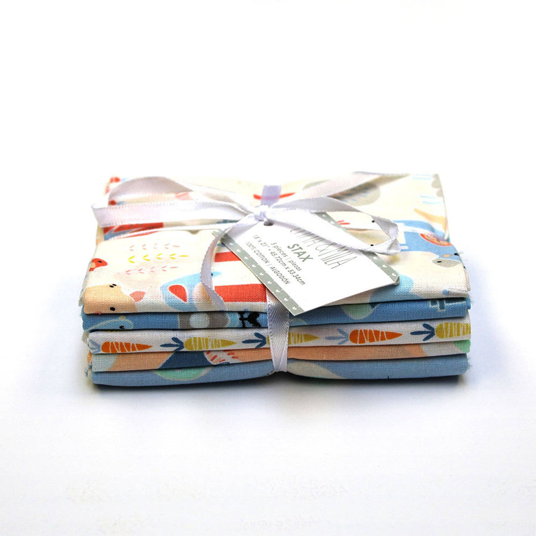 Stack of fabric bundles with a white ribbon on a white background
