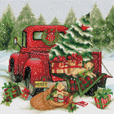 Cross-stitched design of a red truck with Christmas decorations and trees in the background.