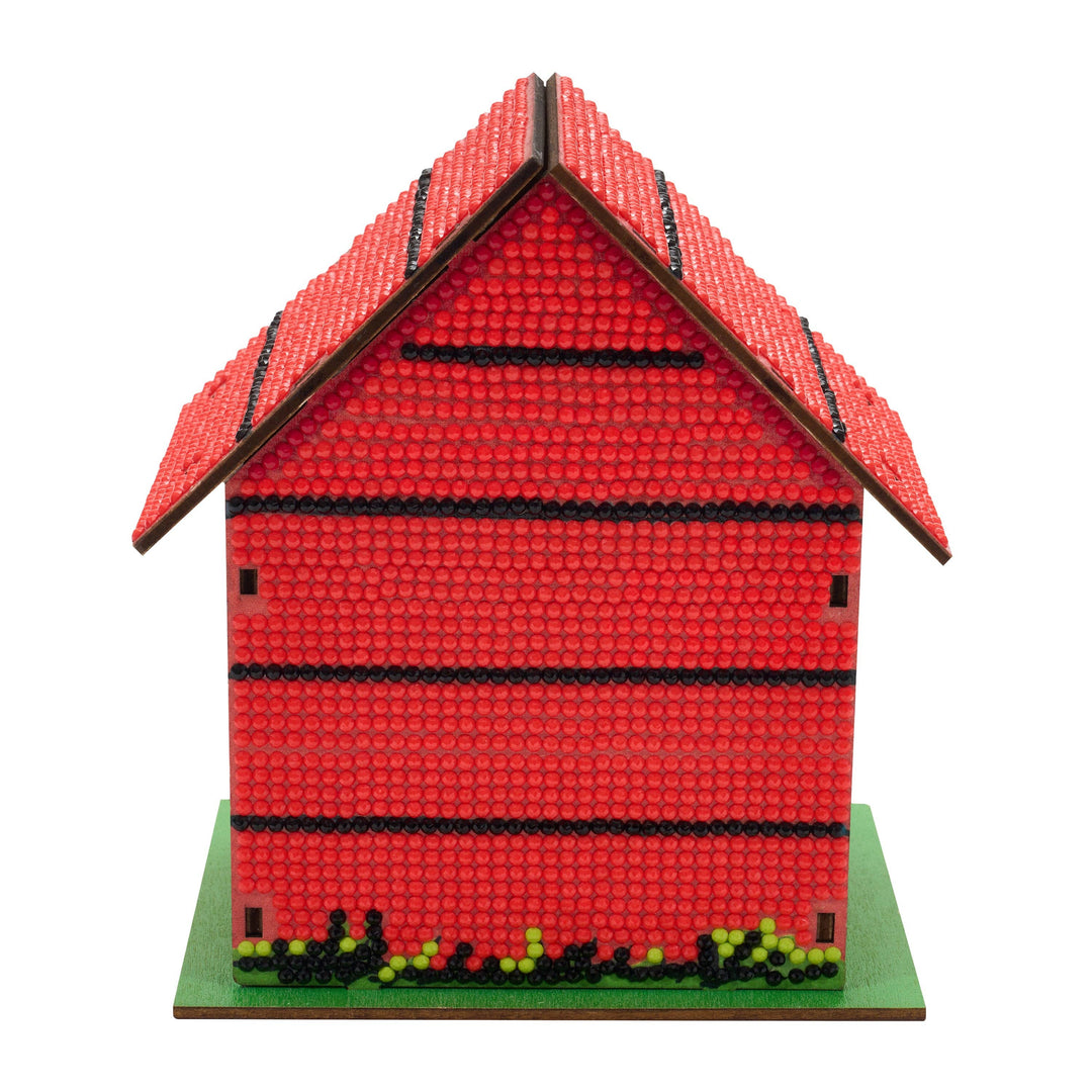 Red model house with a green base on a white background