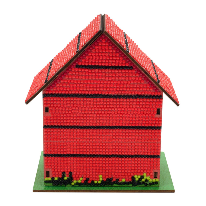 Red model house with a green base on a white background