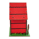 Red toy barn with a green base on a white background