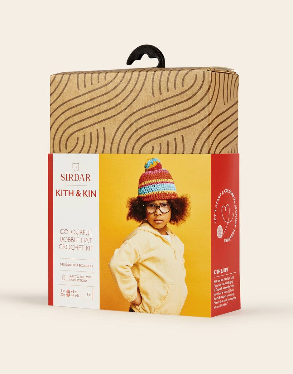 Sirdar Kith & Kin crochet kit packaging with a child wearing a colorful beanie.
