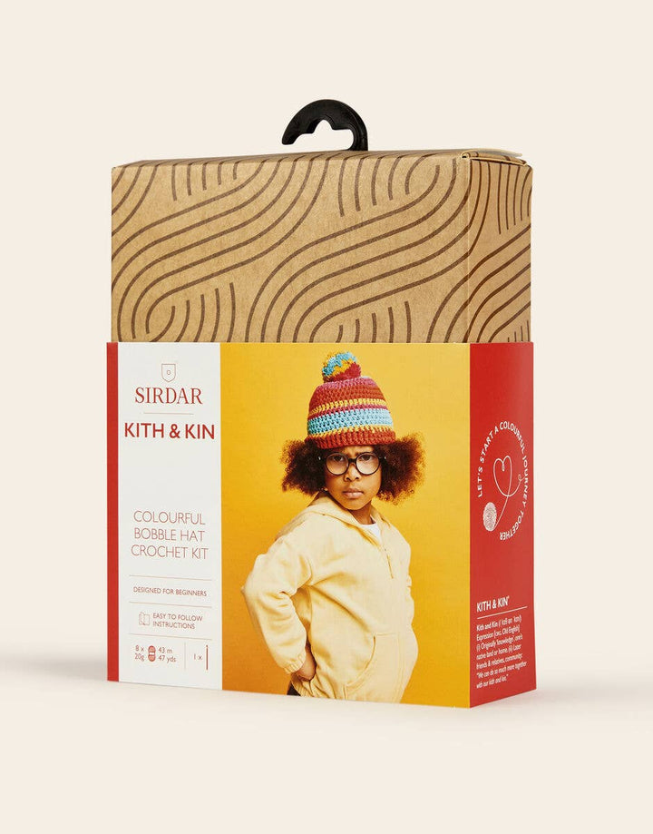 Sirdar Kith & Kin crochet kit packaging with a child wearing a colorful beanie.