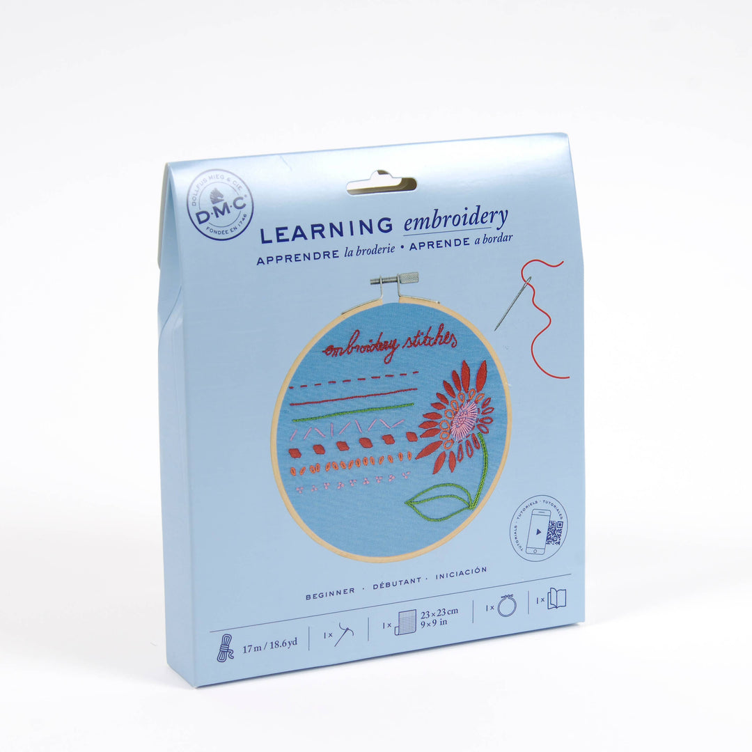 Embroidery kit packaging with a floral design on a light blue background