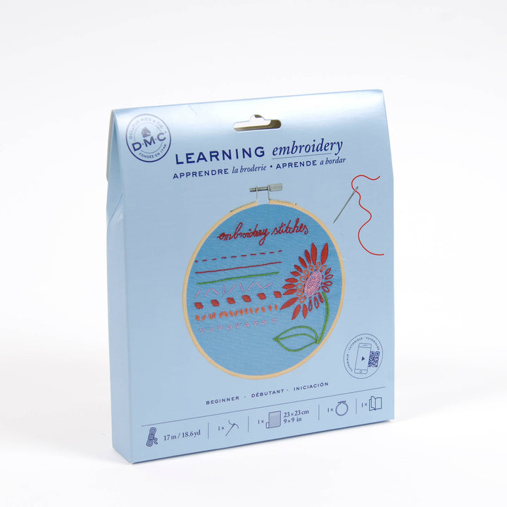Embroidery kit packaging with a floral design on a light blue background