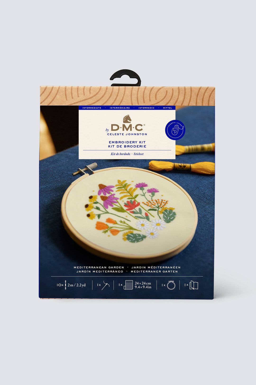 DMC embroidery kit packaging with floral design on a blue surface