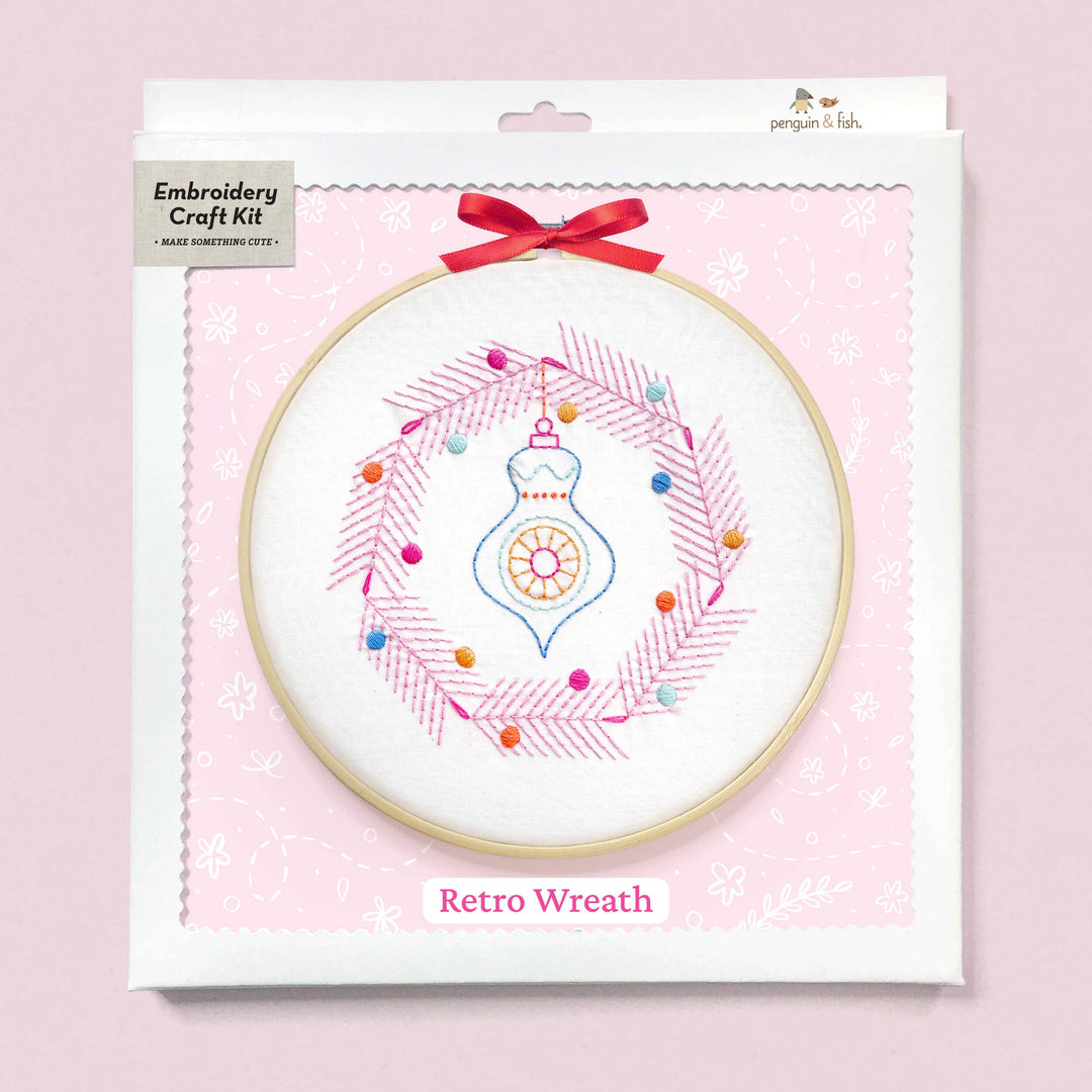 Embroidery craft kit with retro wreath design on a pink background