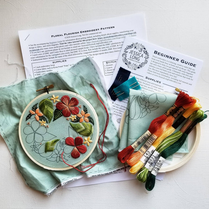Embroidery kit with floral design, threads, and instructions on a light surface