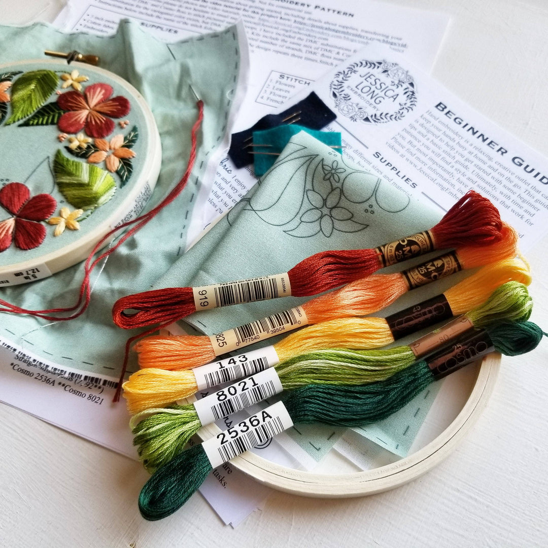 Embroidery hoop with colorful thread skeins and a partially completed floral embroidery design.