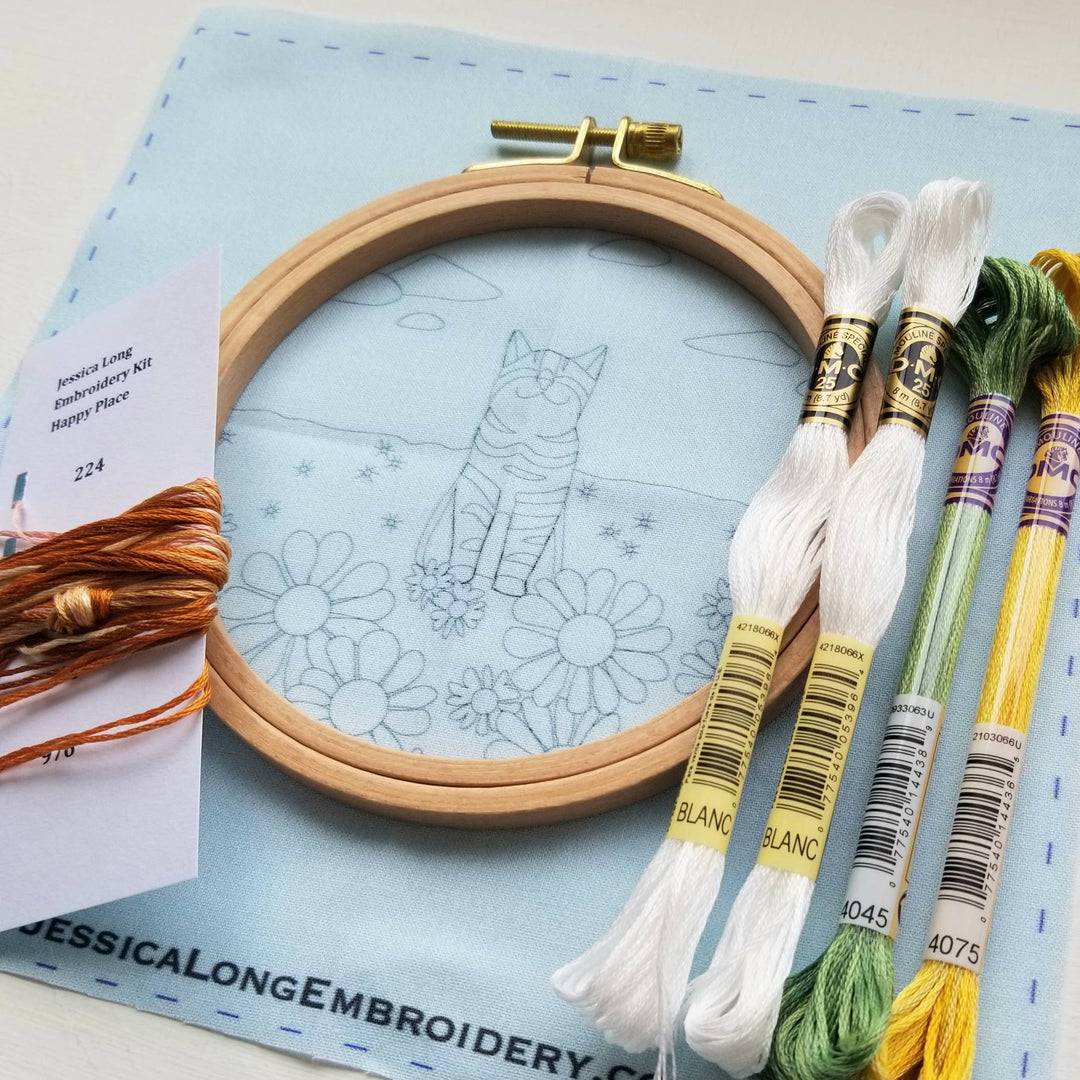 Embroidery kit with hoop, thread, and pattern on a blue mat