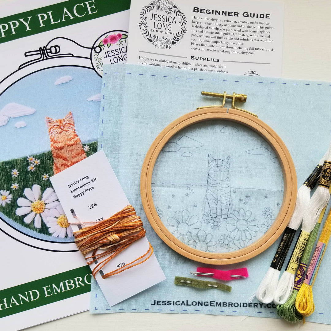 Embroidery kit with hoop, thread, and guides on a blue surface