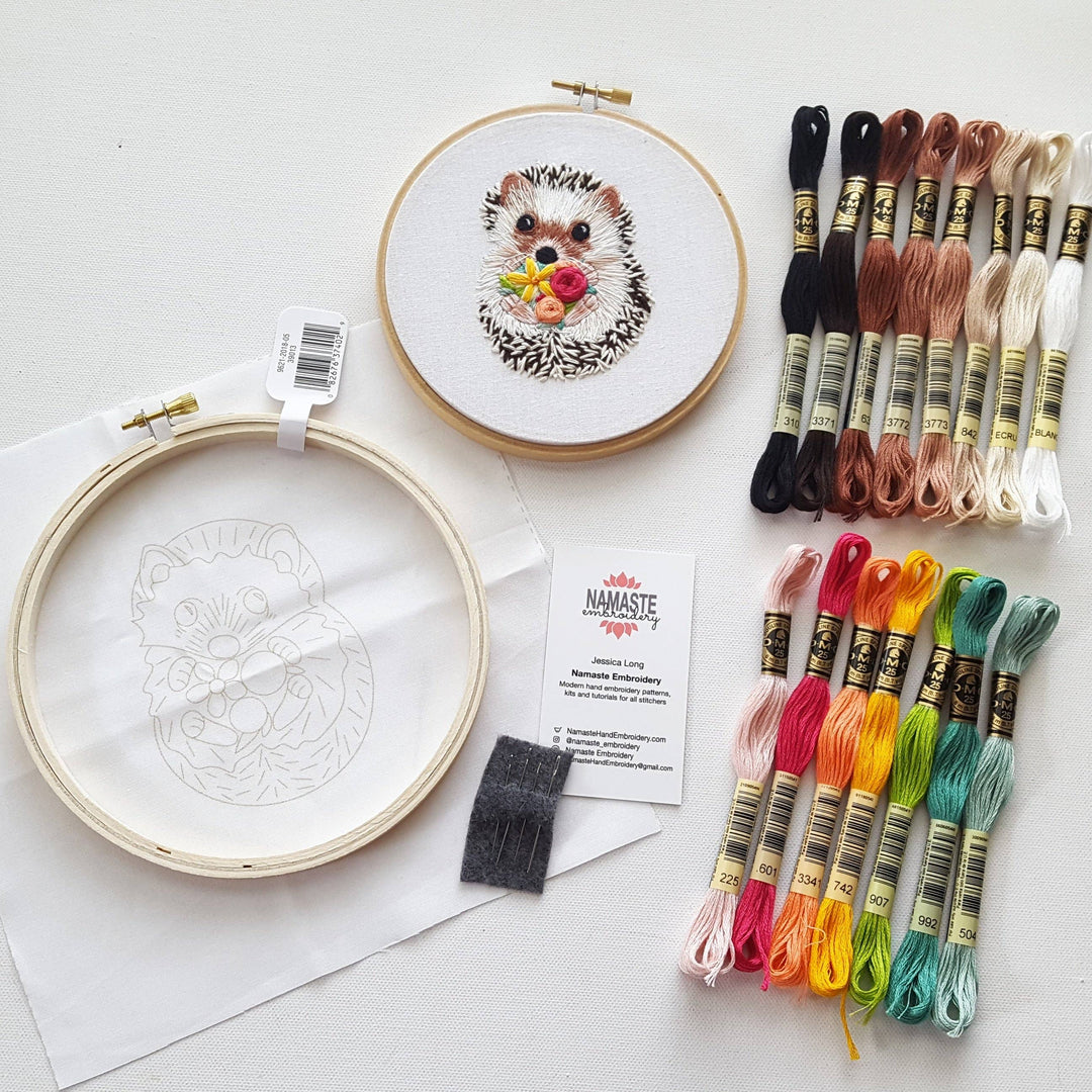 Embroidery kit with hoop, threads, and completed hedgehog design on a white background