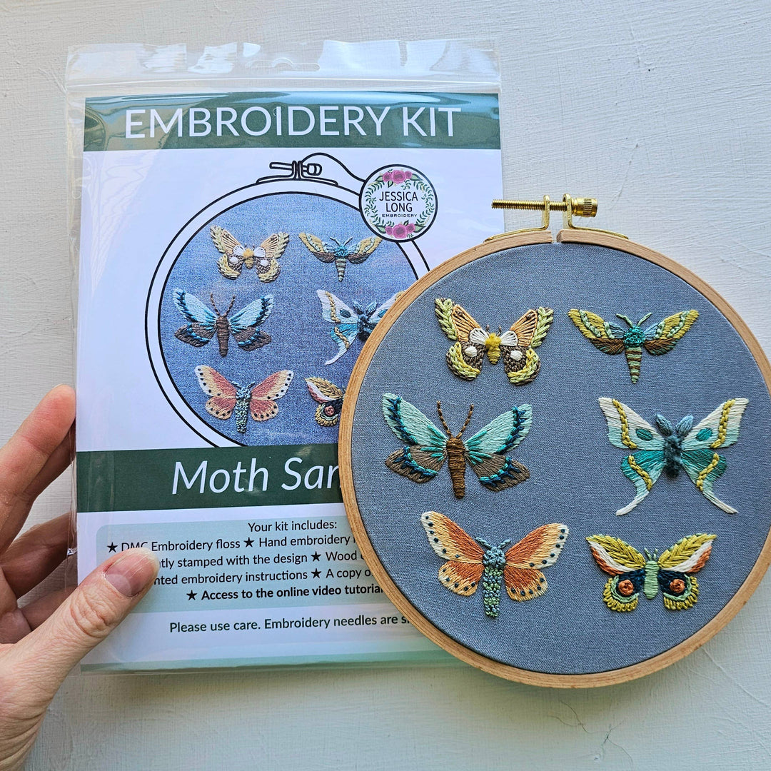 Embroidery kit with embroidered moths and packaging on a white background