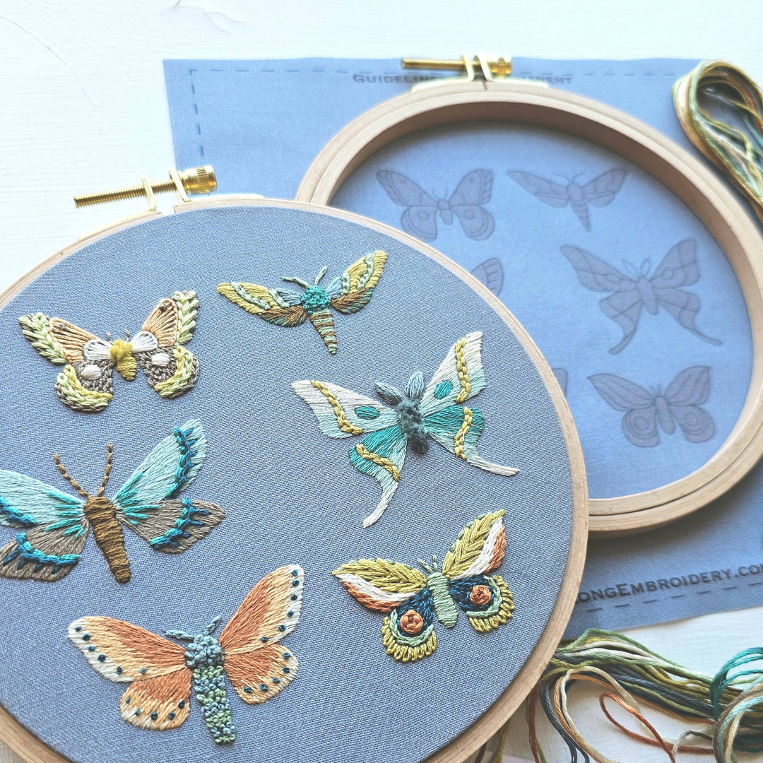 Embroidery hoop with embroidered butterflies on a blue background
