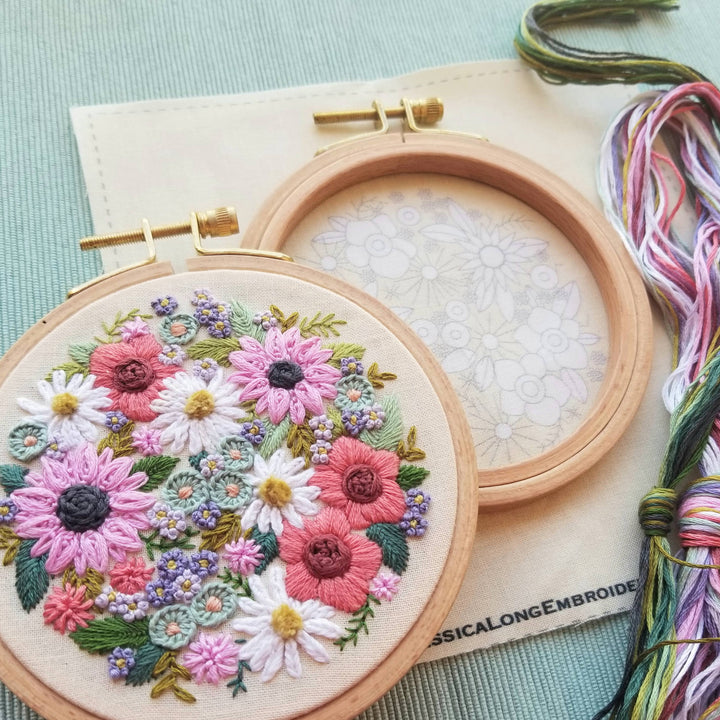 Embroidery hoop with floral design on a light blue background