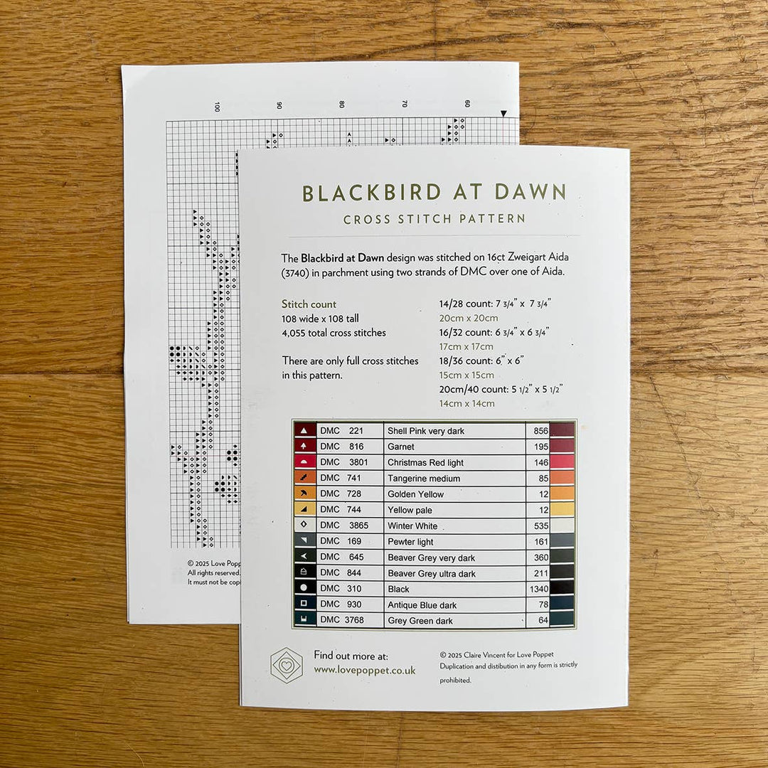 Cross stitch pattern with chart and color chart on a wooden surface