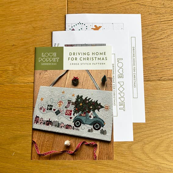 Cross stitch kit with a Christmas-themed design on a wooden surface